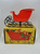 Minter Brothers Vintage Minter Brothers Plastic Candy Filled Santa's Sleigh, red plastic sleigh with wireframe runners placed on a yellow box with festive candy and sleigh design.