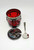 F B Rogers Silver Co Vintage Drum Serving Jar, red and silver decorative jar with black chains, accompanied by a silver spoon and a round silver tray or lid with clock-like markings.