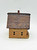 Windy Meadows Pottery School House Clay House, miniature decorative clay model of a rustic school house with a textured brick-like roof and small square windows.