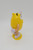 Yellow M&M plastic character case figure that stands 5" tall.  Open the back to retrieve your favorite M&M's or just what you stored there.