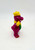 Barney and Friends 1993 Train Conductor Plastic Figure, colorful toy figurine of a purple train conductor with yellow hat and scarf, smiling face, standing on a white background.