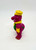 Barney and Friends 1993 Train Conductor Plastic Figure, colorful plastic toy figure of Barney dressed as a train conductor with yellow hat and bow tie, green vest, and purple body with green spots.