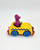 Kid Dimension, Inc. Barney and Friends 1993 Barney Driving Taxi Cab Diecast, a small yellow toy car with blue wheels and a purple Barney figure inside.