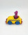 Kid Dimension, Inc. Barney and Friends 1993 Barney Driving Taxi Cab Diecast, a yellow toy taxi with a purple Barney figurine inside, featuring blue wheels and black checkered stripe design.