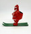 Vintage plastic Santa Claus candy container ornament on green metal skis.  The ornament stands 3.25-inches tall and features a hole on top to hang as an ornament.  The bag is empty to allow placement of candy.