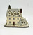 Rhodes Studios 1988 Rockwell's Main Street Collection - Rockwell's Studio, a detailed miniature house model with snow-covered roof, trees, and chimney, featuring multiple windows and a red front door.