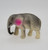 Vintage small Celluloid grey elephant with pink ears toy figure that stands 2 inches high and is 3 inches long.  This grey elephant is in a walking pose with trunk curled up.