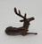 Vintage miniature metal deer deer figure that is 1.75-inches tall. The deer is in a lounging position with one leg under him and other front leg extended out.