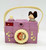 Cabbage Patch Kids Vintage 1984 Cabbage Patch Kids Musical Camera Toy, pink plastic camera with a miniature figurine of a girl with brown hair on top, musical notes decoration, and a small photo window with a child's photo inside.