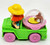 Warner Bros. McDonald's Happy Meal Toy 1991 Tiny Toon Adventures Elmyra, a small plastic figurine with a yellow hat, red dress, blue shoes, and a pink skirt, standing next to a green food truck with a purple dish containing a tiny character inside a glass dome.