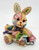Unknown Patchwork Bunny Reading 3" Resin Figurine, colorful patchwork bunny with books, holding a book and a pencil, with detailed painted fabric patterns and expressive eyes.