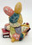 Unknown Patchwork Bunny Reading 3" Resin Figurine, colorful patchwork bunny holding books and reading.
