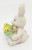 Unknown White With Patchwork Bunny Reading Book 2.25" Resin Figurine, a cute white bunny with pink accents holding a book, and a small yellow chick sitting on a green patch of grass.