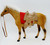 Unknown Caramel Colored Felt Covered Horse Figure with Saddle, toy horse with saddle and bridle, plush and plastic materials, realistic horse design.