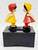 Yaps Vintage Yaps Kissing Doll Music Box Made in Hong Kong, collectible figurines of a boy and girl in colorful outfits on a black music box base.