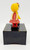 Yaps Vintage Yaps Kissing Doll Music Box, made in Hong Kong, featuring a colorful plastic doll of a girl with a yellow head and red outfit, standing on a black base.