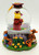 Disney's Winnie the Pooh Graduation Class of 2000 Musical Snow Globe, featuring Winnie the Pooh in a graduation cap and gown inside a glass globe, surrounded by colorful flowers and characters from the Hundred Acre Wood.