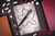Stranger Things by Fred Stranger Things Floaty Pen Set Hellfire Club, a black pen with Stranger Things logo resting on a sketched map with various colorful dice, books, and a drawing sheet.