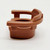 Fisher-Price Original Little People Captain's Chair - Medium Brown, small toy replica of a boat or chair in brown color with a rounded backrest and armrests.
