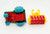 Playmates 1985 Li'l Playmates Farm Play Set - Tractor with Disc Plow, colorful plastic toy tractor with blue wheels and a red body, along with a yellow and red disc plow accessory on a white background.