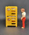 Fisher-Price doll house decorator set #259 Bunk Beds.  The bunk bed set contains 2 plastic yellow beds with striped mattresses.  The set also includes a female figure with a movable head, arms, and legs. She has brown hair, wears a white short-sleeve shirt, and red (brown?) pants.