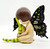 The Hamilton Collection 2013 Butterfly Wishes Collection Soaring Dreams, a decorative figurine of a fairy with black butterfly wings, sitting with her head resting on her hand and wearing a sparkling dress.