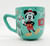 Disney Mickey & Minnie Mouse Joy Christmas Mug, ceramic mug featuring Mickey Mouse dressed in Christmas attire with holiday decorations.