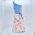 Unbranded Antique Composition 13.5 Inch Blonde Hair Girl Doll, vintage doll with blonde hair, wearing a floral dress and a blue bonnet, side view.