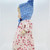 Unbranded Antique Composition 13.5" Blonde Hair Girl Doll, side view of vintage doll with doll's face, blue bonnet, and floral dress.