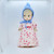 Unbranded Antique Composition 13.5" Blonde Hair Girl Doll, vintage doll with blonde hair, dressed in a pink floral dress with a red ribbon, wearing a blue bonnet.