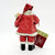 Possible Dreams 1994 Clothtique Santas 7" Baby's First Christmas Santa Ornament, back view of a Santa dressed in red with a hat, coat, and boots, holding a gift, with a tag attached.