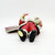 Possible Dreams 1994 Clothtique Santa Claus ornament, baby Santa dressed in red coat and pants, lying on its back with detailed facial features, holding a small bag in one hand, on a white background.