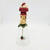 Novelino Inc. Novelino 1992 Christmas Thru The Ages Modern Santa Bell, a decorative Christmas figurine featuring Santa Claus with a sack, standing on a green base with a hanging ornament and a chain at the bottom.