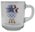 McDonald's 1984 Olympic Games clear glass coffee mug representing the water events of Sailing, Kayaking, Rowing & Swimming events. The mud has the Olympic Games logo, McDonald's logo & the 1984 Games red, white & blue stars on the opposite side. The mug stands 3.25-inches tall and 3" Wide without the handle.