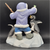 What a Catch! figurine features a Eskimo boy holding fish at his fishing hole with 2 penguins in front of him. The boy is wearing blue pants  and purple jacket holding his fishing rod. The figurine is a hand painted porcelain figurine crafted in Malaysia. Michelle Emblem's figurine is 6.5-inches wide by 7-inches tall and 5-inches deep.