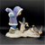Watch Out figurine features an Eskimo boy chasing 2 penguins in front of him. The boy is wearing blue pants and purple jacket holding his arms out like the penguins. The figurine is a hand painted porcelain figurine crafted in Malaysia. Michelle Emblem's figurine is 8-inches wide by 6.5-inches tall and 4-inches deep.