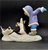 Watch Out figurine features an Eskimo boy chasing 2 penguins in front of him. The boy is wearing blue pants and purple jacket holding his arms out like the penguins. The figurine is a hand painted porcelain figurine crafted in Malaysia. Michelle Emblem's figurine is 8-inches wide by 6.5-inches tall and 4-inches deep.