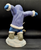 Watch Out figurine features an Eskimo boy chasing 2 penguins in front of him. The boy is wearing blue pants and purple jacket holding his arms out like the penguins. The figurine is a hand painted porcelain figurine crafted in Malaysia. Michelle Emblem's figurine is 8-inches wide by 6.5-inches tall and 4-inches deep.