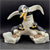 Which Way? figurine features a Penguin with a young penguin holding onto each leg. The figurine is a hand painted porcelain figurine crafted in Thailand. Michelle Emblem's figurine is 7-inches wide by 5.5-inches tall and 3-inches deep.