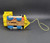 Vintage Fisher-Price 1964 #643 Toot-Toot Engine pull along toy. Wooden cut-out train engine with a rounded boiler that has red paper lithographs on the sides with a blue "sign" marked "Toot Toot" in white. The engine has a yellow plastic front grill and cowcatcher, a yellow plastic cab with a roof, a BLACK wooden smoke stack with small white squares on top, and 4 BLUE wooden wheels with white plastic pistons attached. When pulled, the pistons move and the engine makes a "chug-chug" sound. The model number is marked in small print by the cow catcher. Measures 6-1/4" long, 4-1/4" high, 3-1/4" wide.