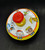 Ohio Art toy spinning top with circus train lithographs that is 5.25-inches diameter. The circus train features conductor pulling 4 cars with elephant, lion, bear and giraffe in the caged train cars. There is a dog with balloons on unicycle following the train.