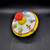 Ohio Art toy spinning top with circus train lithographs that is 5.25-inches diameter. The circus train features conductor pulling 4 cars with elephant, lion, bear and giraffe in the caged train cars. There is a dog with balloons on unicycle following the train.
