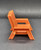 Fisher-Price Doll House Decorator set #260 Patio Set lawn chair. The Orange (brown-orange) lawn chair is 2 1/4" tall and 2" wide and 2 1/4" deep. This was available 1979-1984.