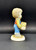 Campbell's Soup Kid 4-inch tall ceramic figurine of a boy carrying a case of Campbell's Soup. The boy is wearing blue overall with red shirt and has brown hair.