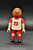 Geobra the German manufacture of Playmobil 2006 white jersey footballer / soccer player from the Playmobil 4700 Soccer Football Stadium set. The figure is wearing a white jersey with red sleeves, shorts and socks. The jersey also has FAIR in red letters across the front and 23 as soccer jersey number. The player has lever to create a kicking motion.