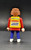 Geobra the German manufacture of Playmobil 1992 Headphone wearing Crew Member from 3091 Formula One Pit Crew Team 3-inch tall figure for ages 3+. The figure is wearing a red shirt with yellow jacket and blue pants. The crew member is missing his hat and headphones.