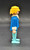 Geobra the German manufacture of Playmobil 1974 Policeman 3-inch tall figure for ages 4+. The figure is wearing dark blue shirt with white collar  and light blue pants. The policeman is missing his helmet and accessories.