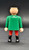Playmobil GEOBRA PLAYMOBIL 2002 3174 Red Pirateship Pirate 3" Figure (Part #30007040), rear view of a 3-inch toy pirate figure wearing a green shirt, red pants, and black boots against a dark background.
