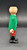 Playmobil GEOBRA PLAYMOBIL 2002 3174 Red Pirateship Pirate 3" Figure (Part #30007040), side view of a vintage toy pirate figure wearing a green coat, red pants, and black boots against a dark background.