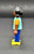 Geobra the German manufacture of Playmobil City Life basic black girl figure that stands 2-inches tall for ages 4+. The figure is wearing a blue shirt with goldfish, peach sleeves, blue pants and has black hair. The figure was exclusive to Germany.